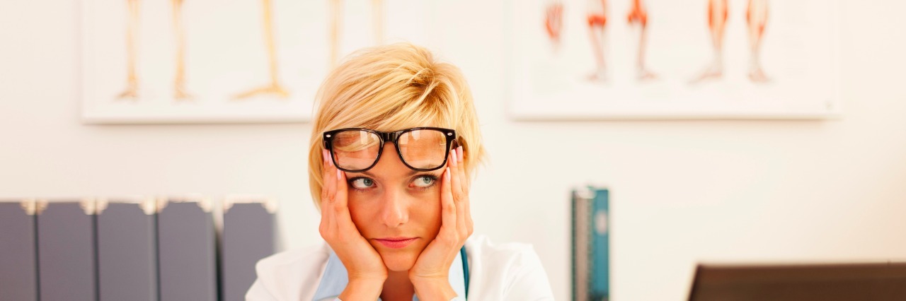 A Letter to the Urgent Care Doctor Who Rolled His Eyes at Me Desperate female doctor sitting at her office