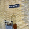 Kings Cross station wall visited by fans of Harry Potter to photograph sign for platform nine and three quarters with trolley