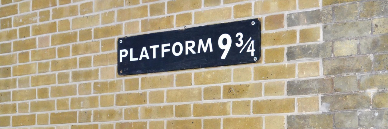 Kings Cross station wall visited by fans of Harry Potter to photograph sign for platform nine and three quarters with trolley