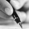 Black and white photo of person holding a pen
