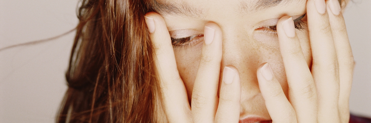 Woman covering face with hands