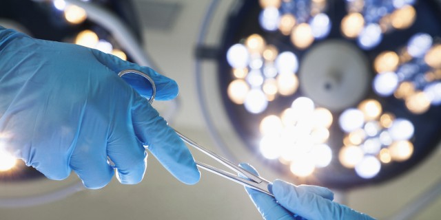 No, an Appendectomy Won't Cure Pseudomyxoma Peritonei Close-up of gloved hands passing the surgical scissors