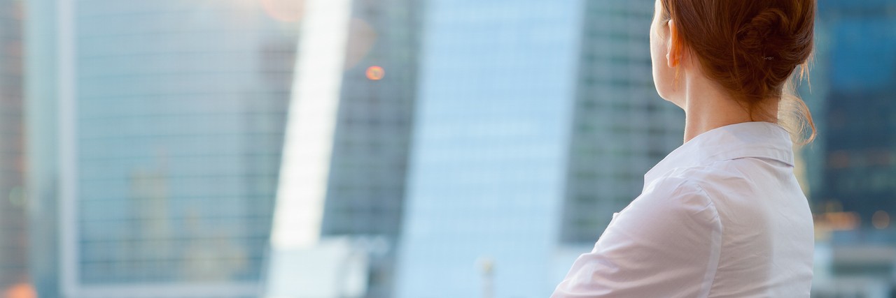 How to Be Successful When You're Too Sick to Work Full Time Business woman looks at the modern city downtown