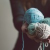 Hands holding balls of yarn