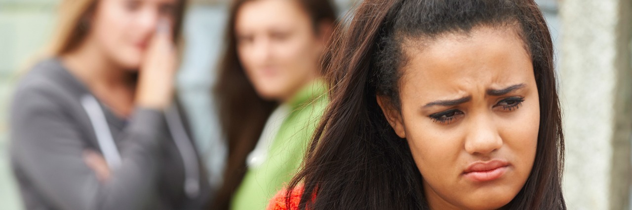 Unhappy Teenage Girl Being Gossiped About By Peers