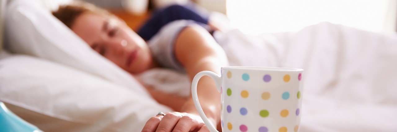 Waking Up With Bipolar Disorder Woman in bed reaching for her mobile phone on nightstand