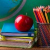 Stack of books, red apple, globe and pencils