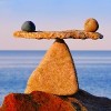 two rocks balancing on a rock scale