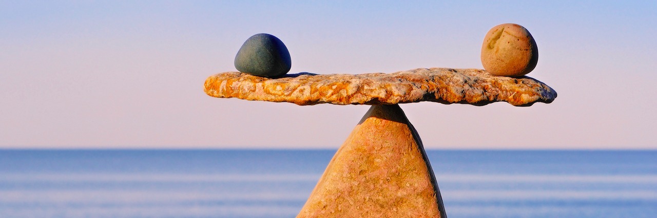 The Balance of Helping Someone Who's Suicidal two rocks balancing on a rock scale