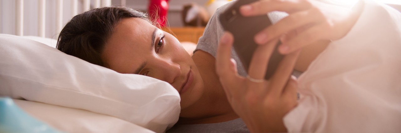 Depression and Anxiety: What Starting the Day Is Like for Me Woman Lying In Bed Checking Messages On Mobile Phone