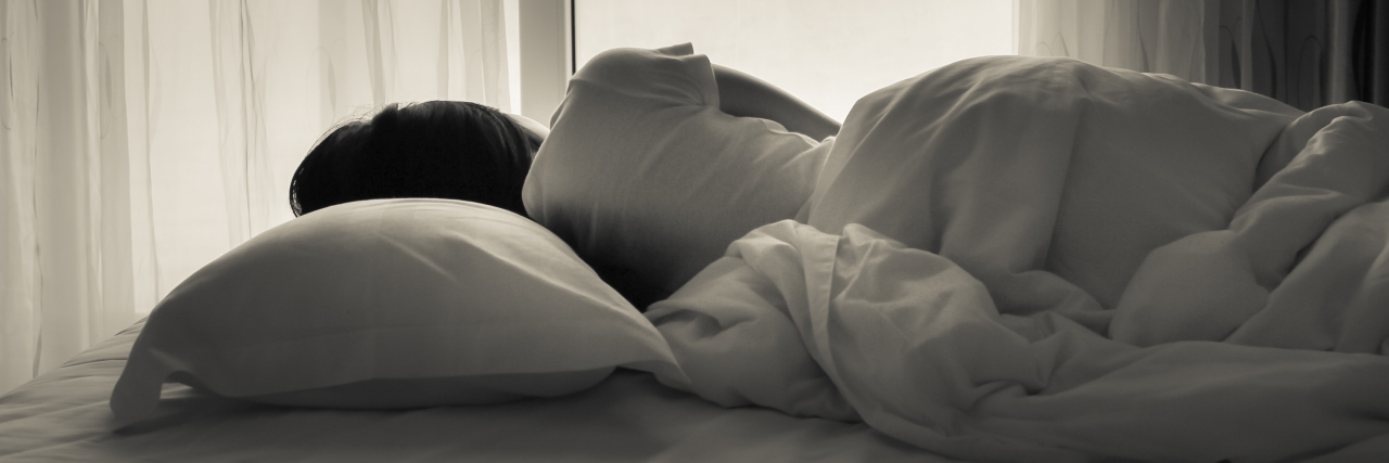Friends and Family Understanding My Depression and Anxiety Young woman lying in bed, looking towards through the window - black and white photo.