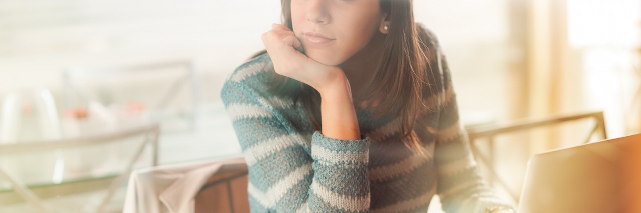 Pensive woman with laptop