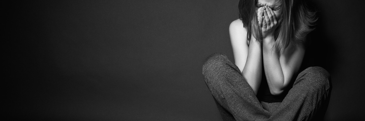 What Cluster Headaches Feel Like and Why We Shouldn't 'Tough It Out' woman holding hands on face, black background