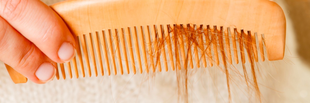 Trichotillomania: Don't Tell Someone to Stop Pulling Out Her Hair Female hand combing long hair.