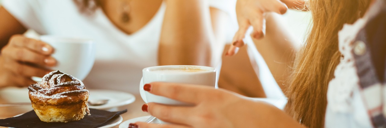 two women having a conversation over coffee