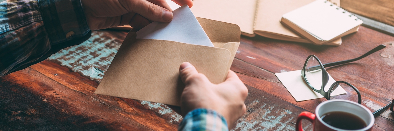 a woman putting a letter in an envelop