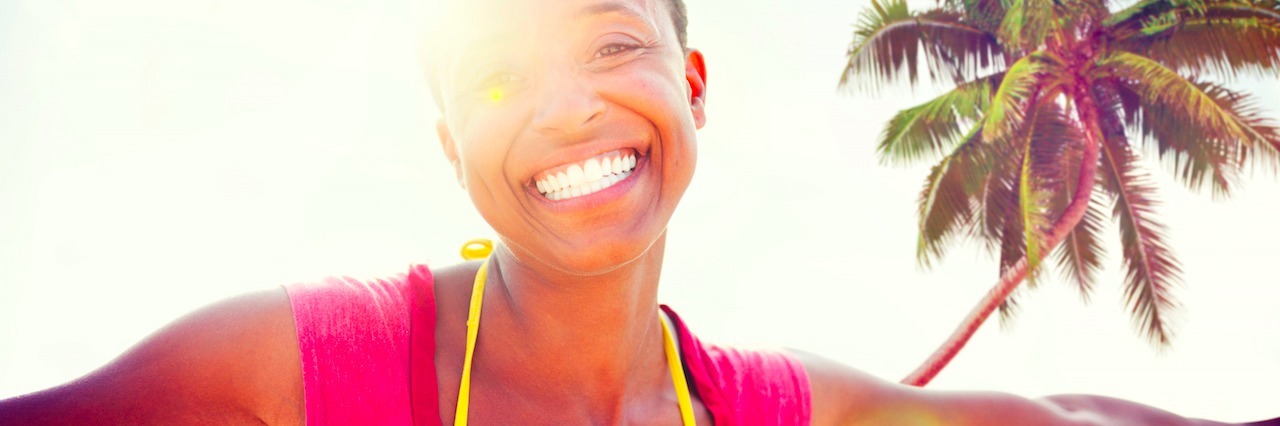 The Difference Between Self-Care and Pampering Young woman relaxing on a tropical beach