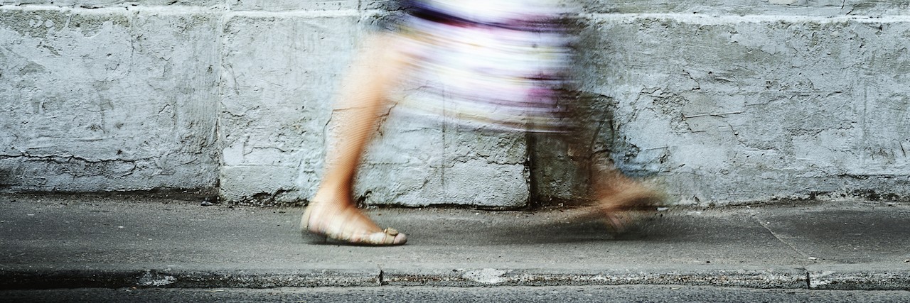 a woman walking on the sidewalk