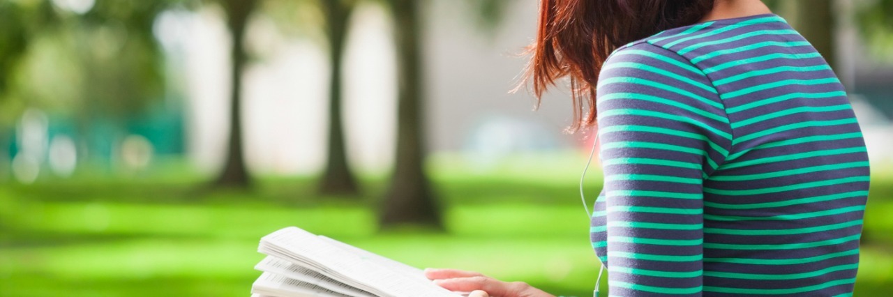Advice for College Students With Fibromyalgia Student sitting on bench, reading on college campus