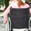 woman wheeling wheelchair on path