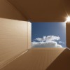 Conceptual shot illustrating the phrase 'thinking outside the box'. Implies inspirational thoughts, bright new ideas, imagination and escaping from the norm. The box has areas for copy space. Carefully positioned to show the bright blue sky and also lens flare from the sun.