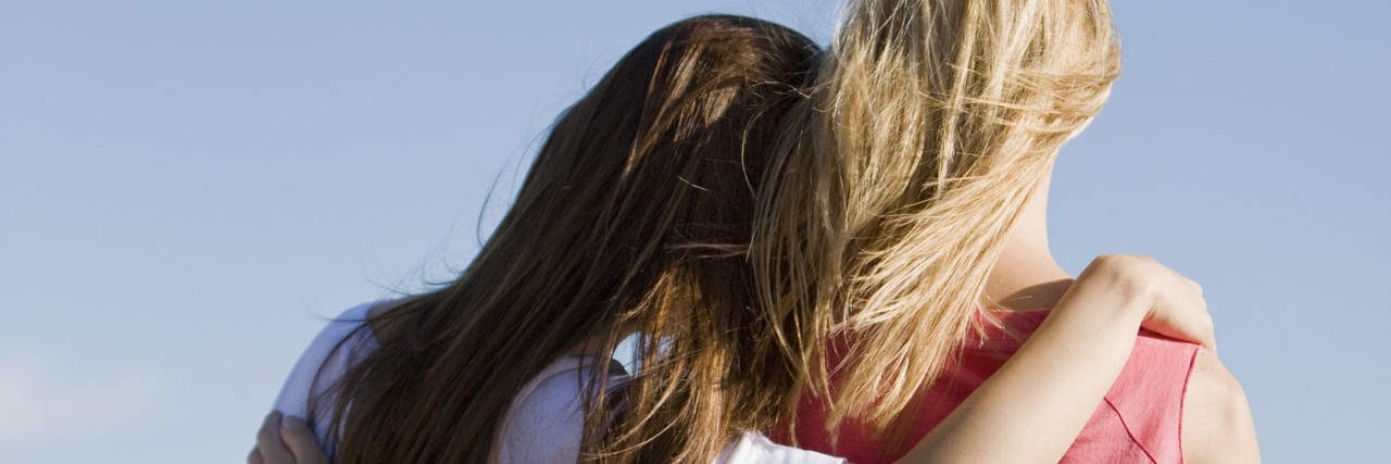 Making Friends in the Chronic Illness Community and Feeling Less Alone Two women with arms around each other, looking at a landscape