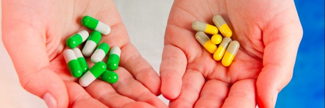Medical pills green, yellow, grey, white in human's hands