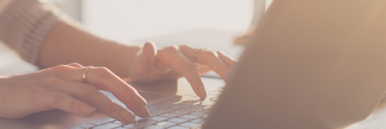 How Writing About My Chronic Illness Helps Me and Helps Others Close-up of hands typing on a laptop
