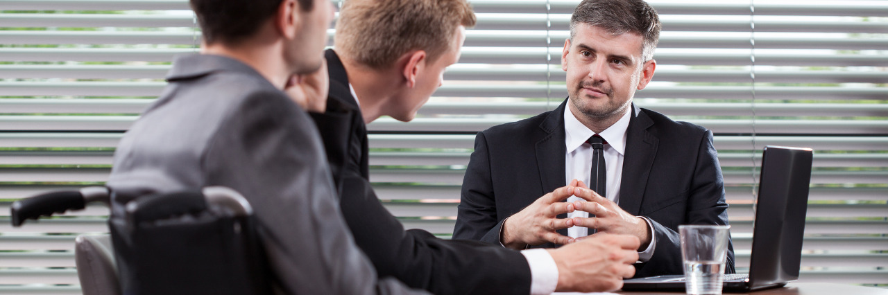 Stereotypes About Hiring People With Disabilities Hold Employers Back Disabled man at a business meeting.