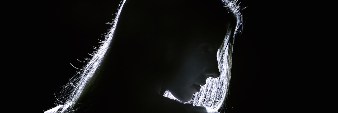 When a Person With Anxiety Thinks Friends Are Judging Them sad woman profile silhouette in dark