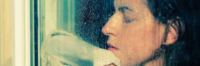 girl looking through a rainy window