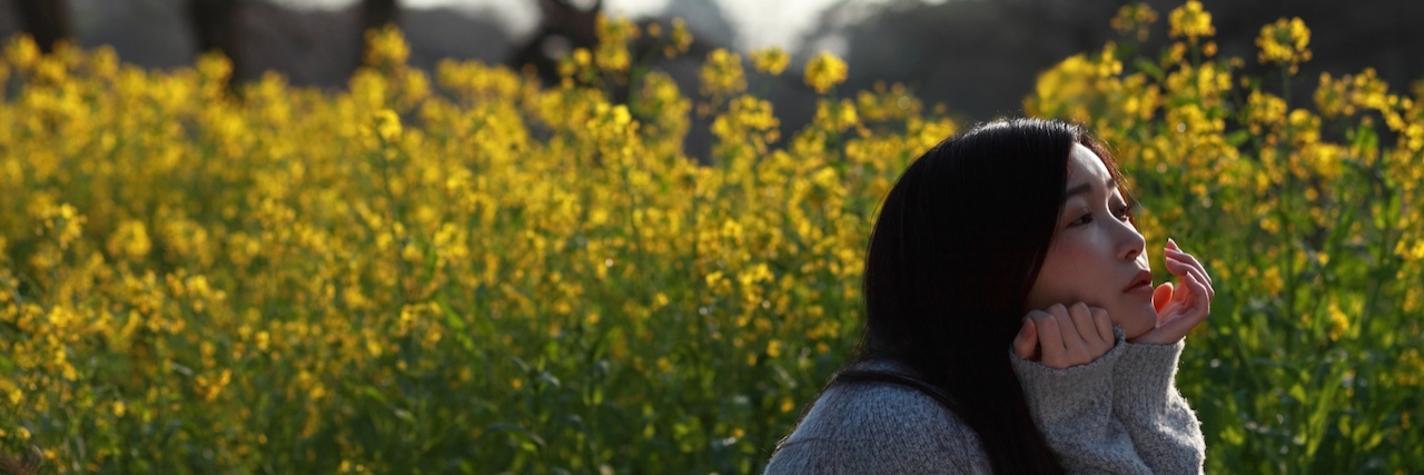 What I Want You To Know About Me And My Lupus and Avascular Necrosis woman with chin on hands in field