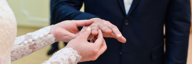 bride and groom putting rings on fingers