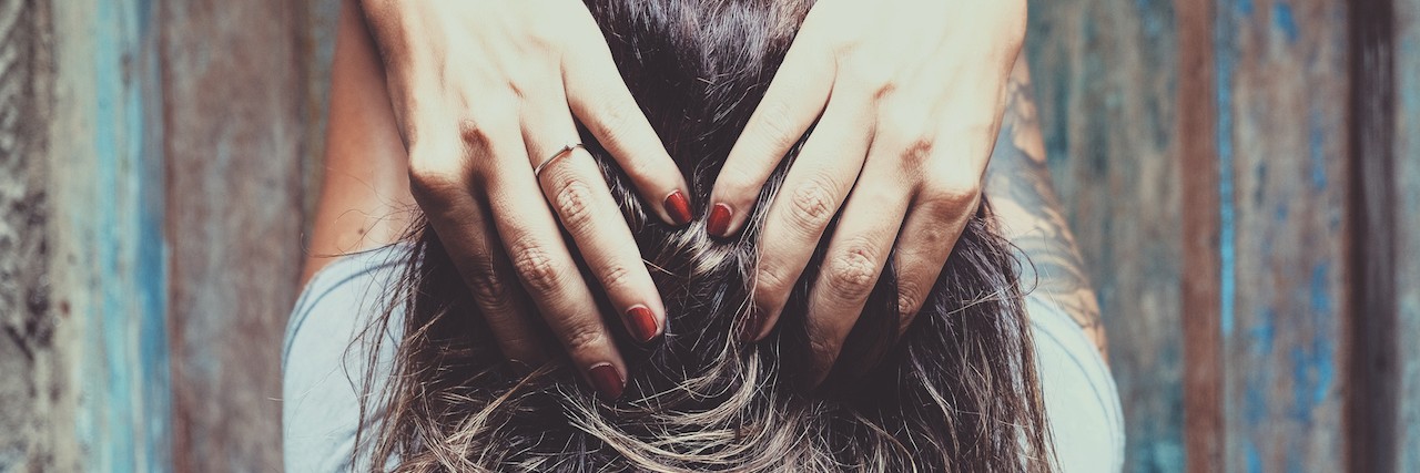 There's Not Enough Awareness About Trichotillomania woman running her fingers through her hair