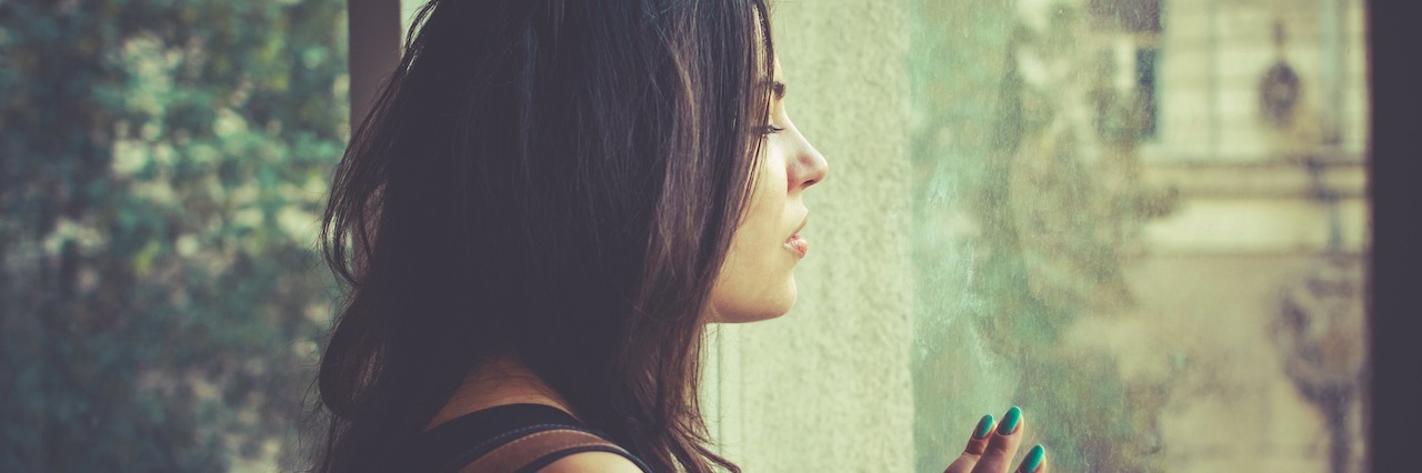 The Downsides and Silver Linings of Chronic Fatigue Syndrome Young woman looking through the window