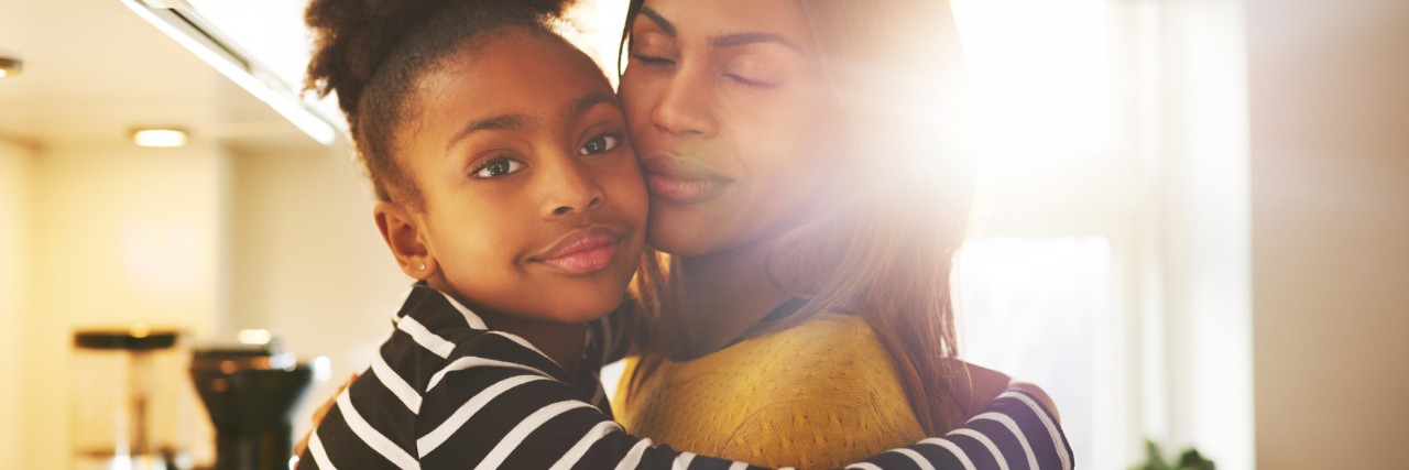 Why Talking About My Mom’s Bipolar Disorder Helps Me Cope Loving child hugging mother looking at camera looking calm