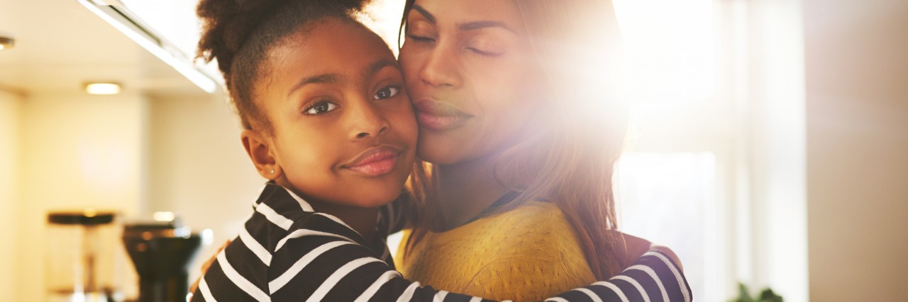 Loving child hugging mother looking at camera looking calm