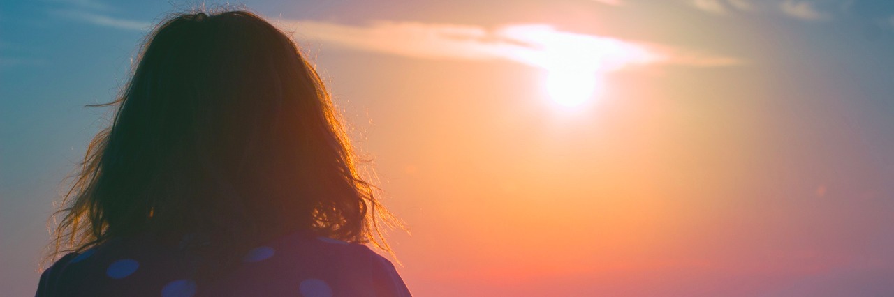 Poem for Those Struggling and Want to Reach Out Girl watching the sunset/sunrise over sea.