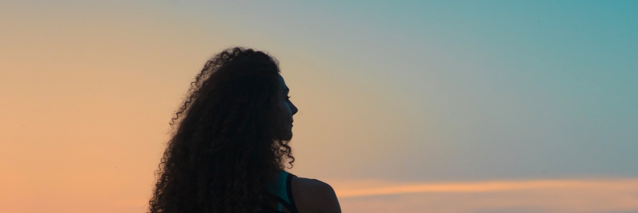 What Living With an Anxiety Disorder Is Like for Me Silhouette of woman in front of the sky at sunset