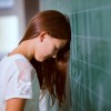 Little girl leaned her head on the blackboard