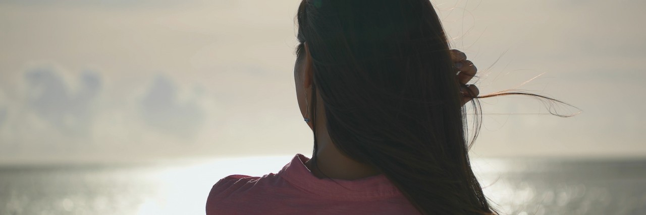 Why Eating Disorder Recovery Is Not About 'Wanting It Enough' young woman facing the water at the beach