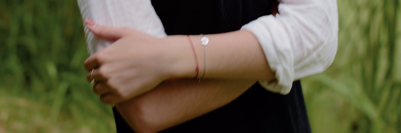 Do Not Tell People Who Cut to 'Just Stop Cutting': Here's Why Portrait of serious young woman in white shirt standing in nature with arms crossed and looking at camera.