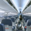 Abstract blurred aircraft cabin view of economy class with passenger background. Travel concept with public aviation transport.
