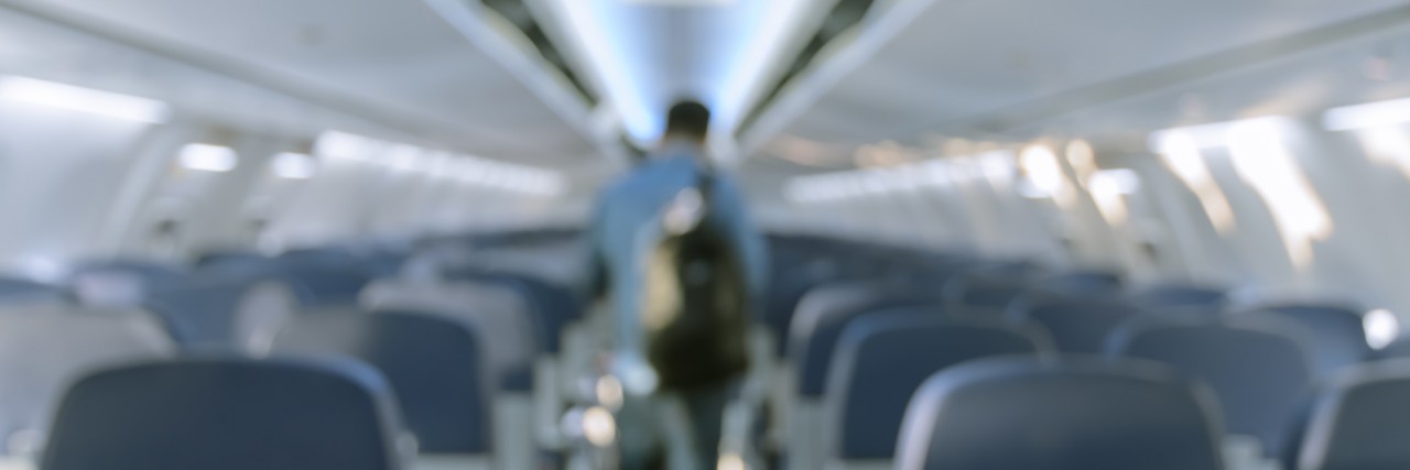 Special Needs Dad Is 'That Guy' on the Plane Abstract blurred aircraft cabin view of economy class with passenger background. Travel concept with public aviation transport.