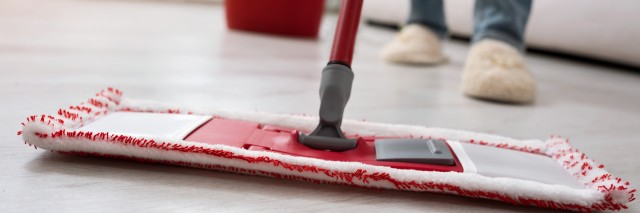 Closeup of human cleaning mopping floor