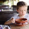 7 years old child, boy eating soup in restaurant