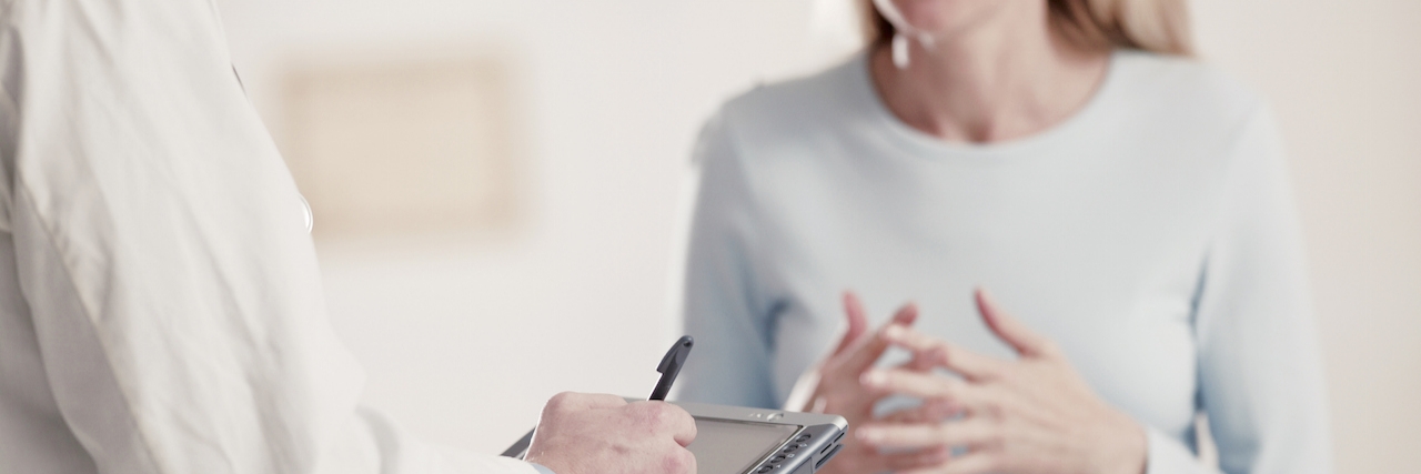 A Letter to Doctors About Seeing Patients With Chronic Pain Doctor holding tablet PC talking to patient