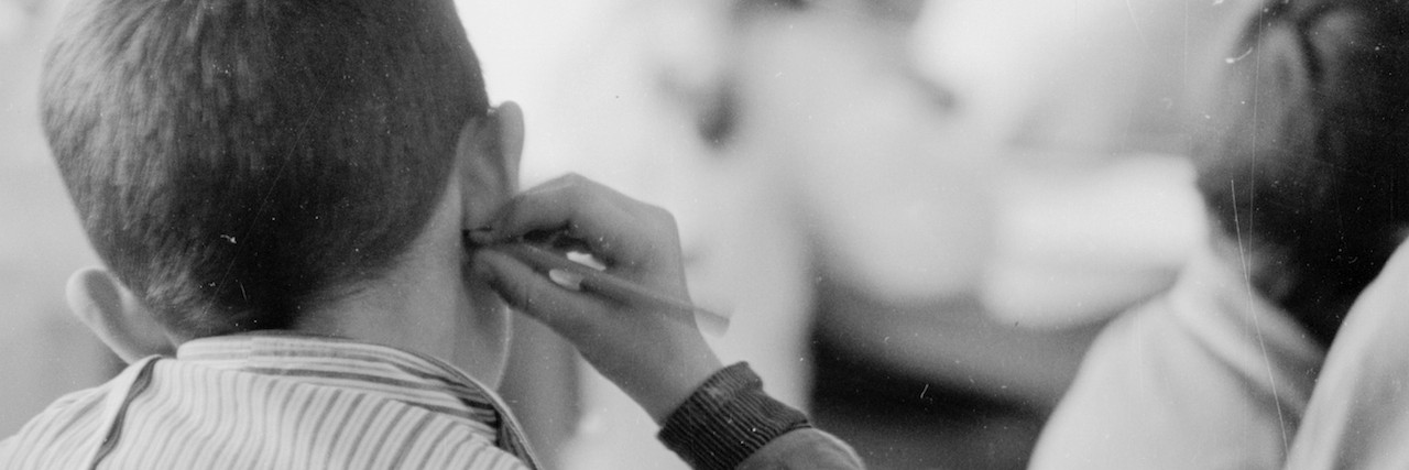 A Letter to the Mom Who's Scared of an Autism Diagnosis for Your Child Black and white photo of boy at school sitting at desk