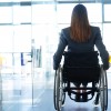 rear view of a businesswoman sitting in a wheelchair in an office