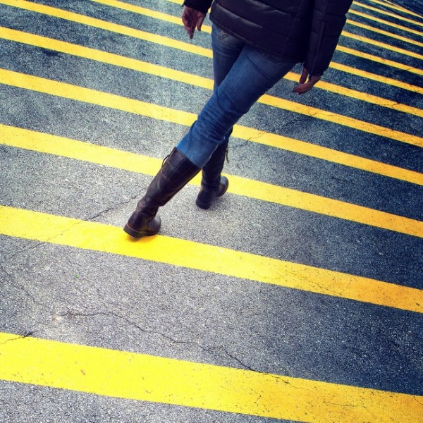 woman walk on asphalt floor with yellow lines